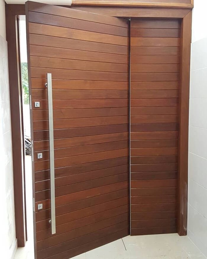 Porta de madeira com parte fixa lateral complementando o vão