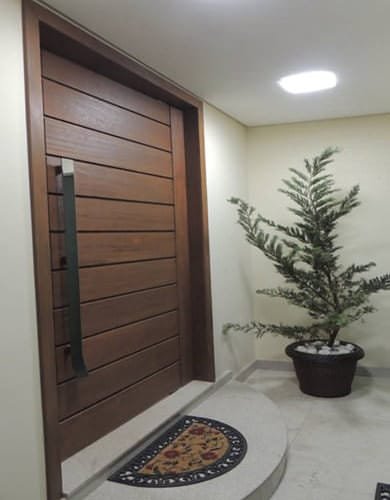 Porta pivotante de madeira com verniz escuro